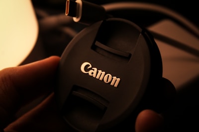 Close-up photo of a Canon printer being connected to a laptop via USB cable.