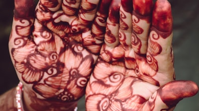person with red and white floral nail art