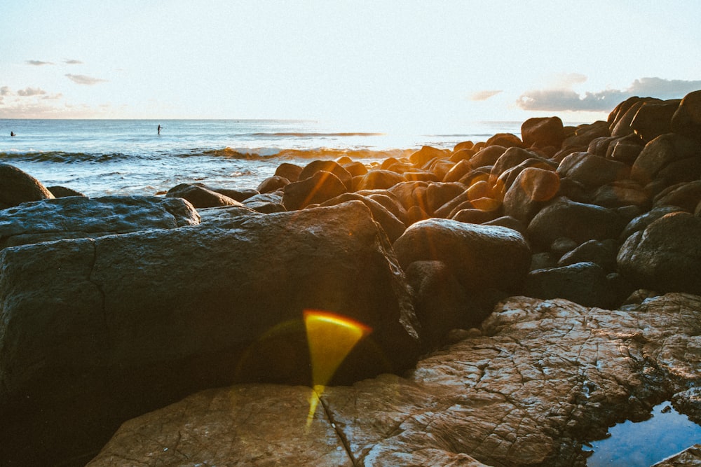 Rocce marroni in riva al mare durante il giorno