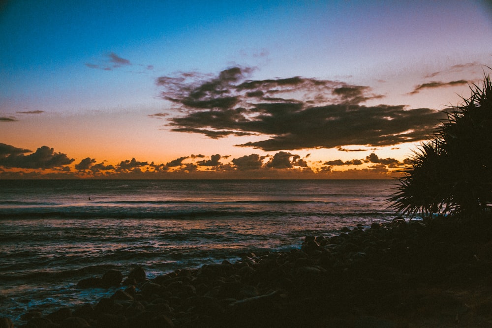 body of water under blue sky during sunset