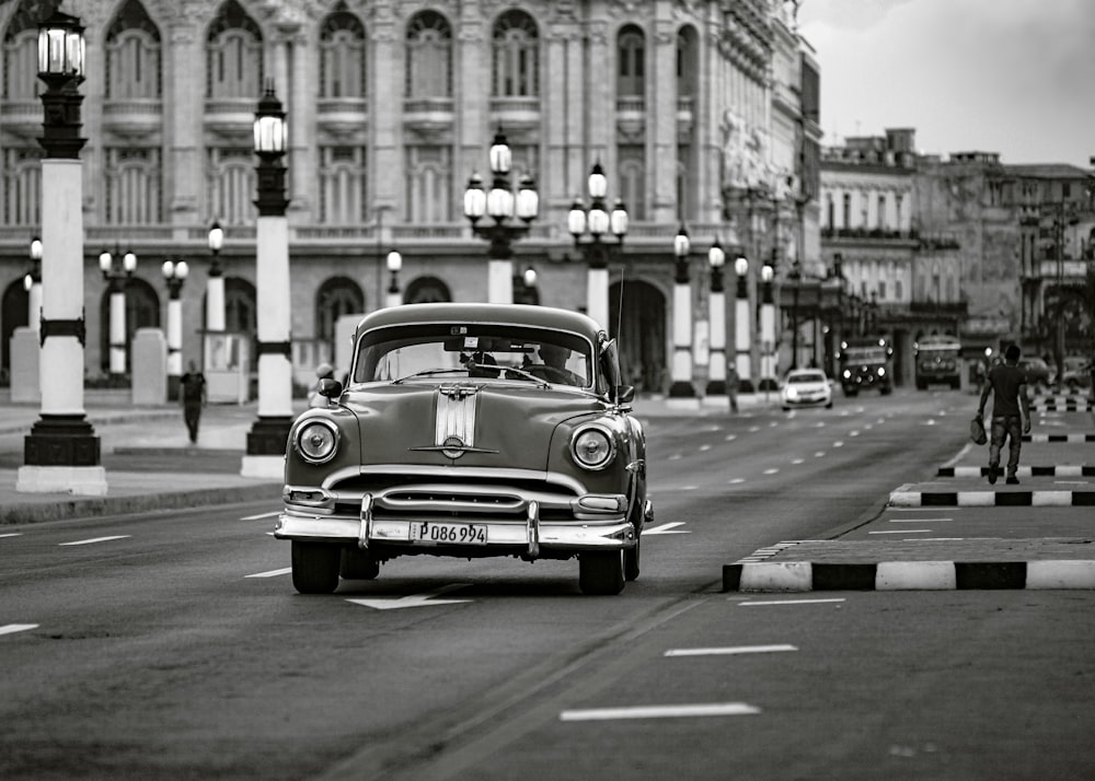 grayscale photo of classic car on road