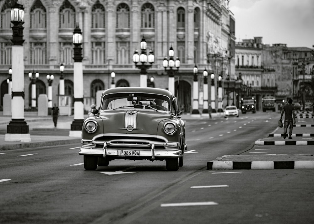 foto em tons de cinza do carro clássico na estrada