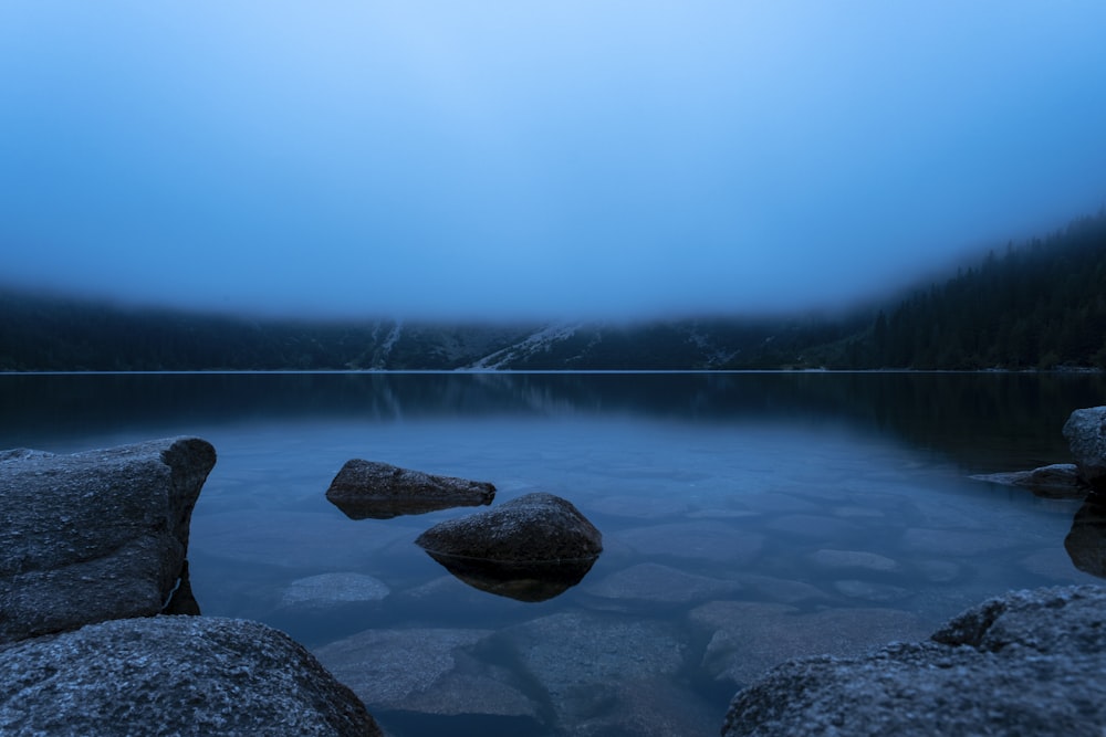 brown rock formation on body of water during daytime