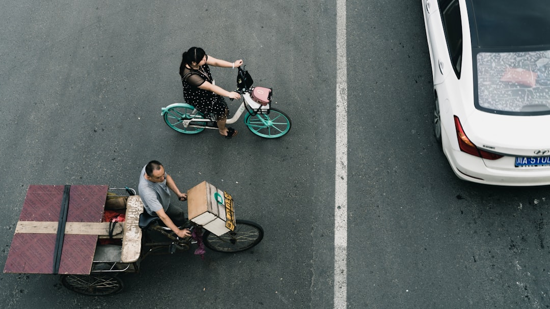 man and woman riding bicycle on road during daytime