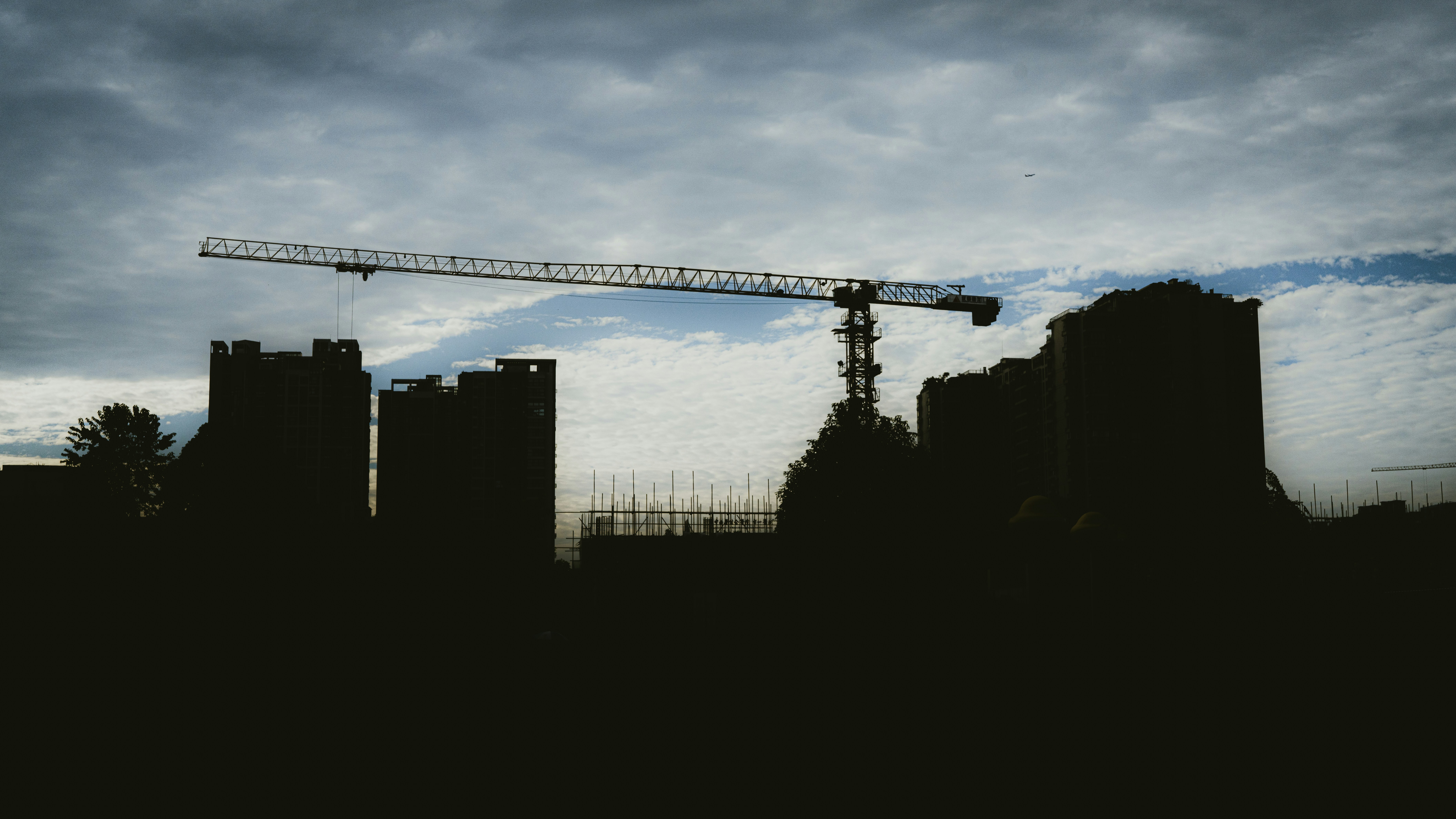 silhouette of buildings under cloudy sky during daytime