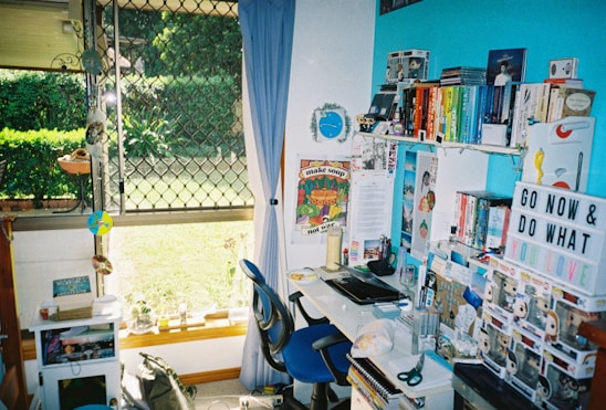 A bright, welcoming workspace filled with colorful office supplies and stacks of books, reflecting Qatar's vibrant educational and corporate environment.