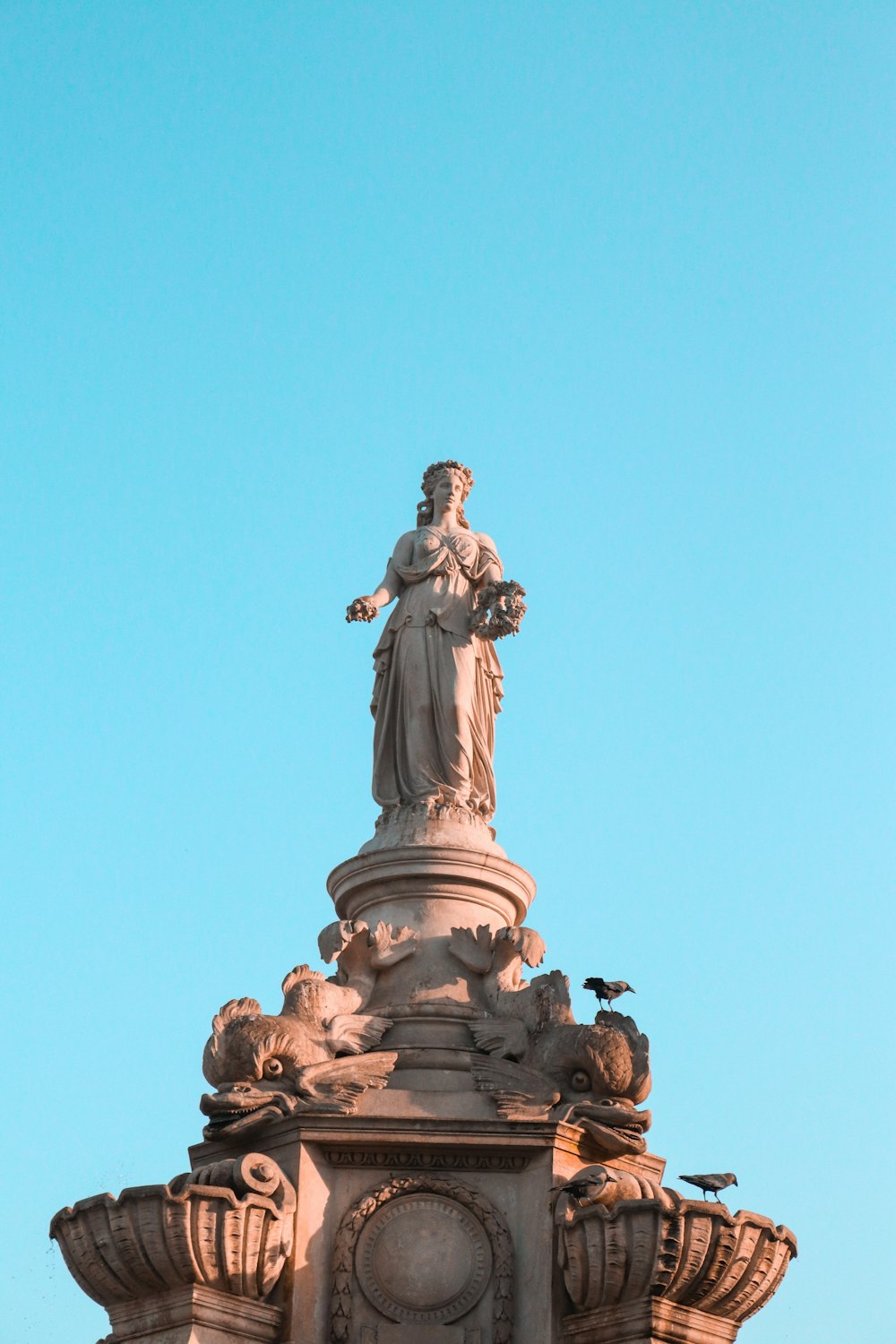 man in robe statue under blue sky during daytime