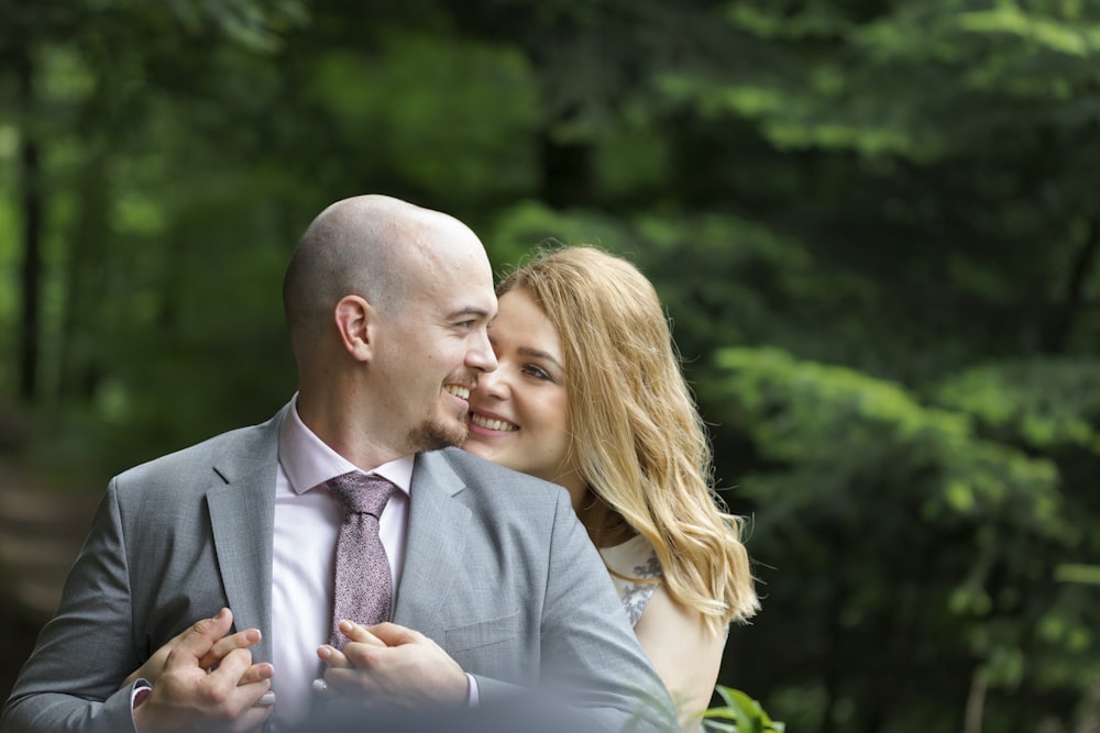 man in gray suit jacket kissing woman in white dress