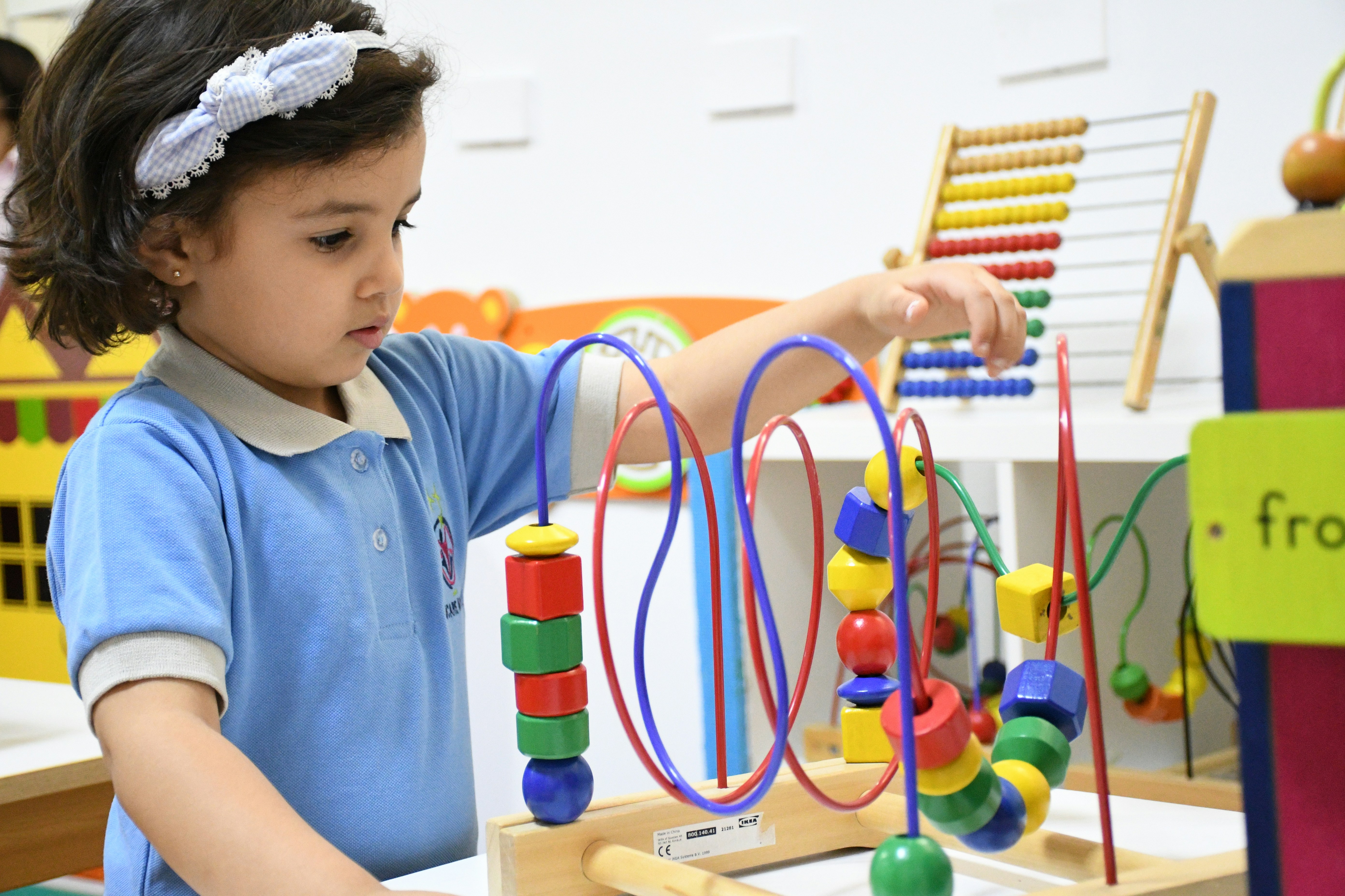 boy in blue polo shirt playing with lego blocks