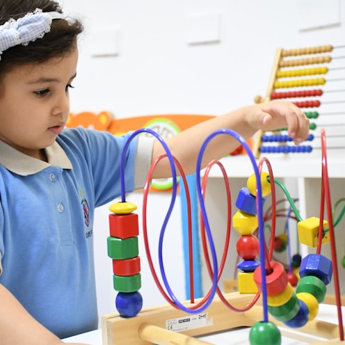 boy in blue polo shirt playing with lego blocks