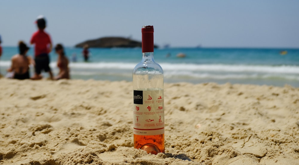 日中のビーチにある透明なガラス瓶