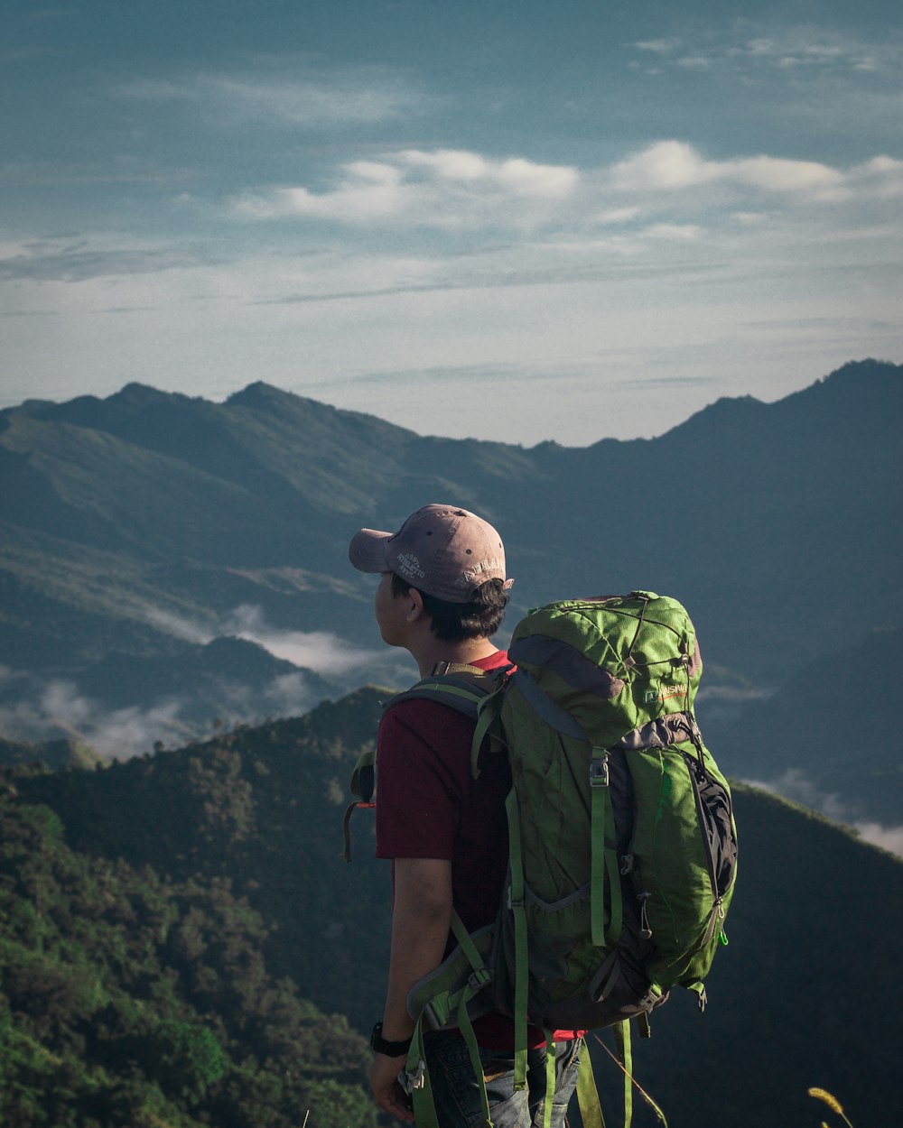 man in black backpack standing on top of mountain during daytime