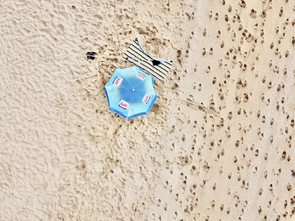 blue and white paper boat on white sand