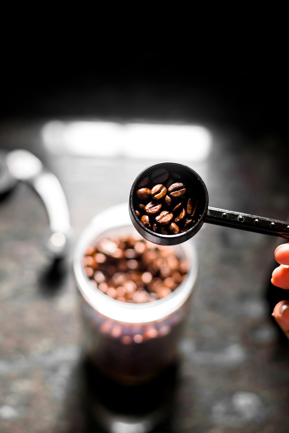 person holding white ceramic mug with coffee beans