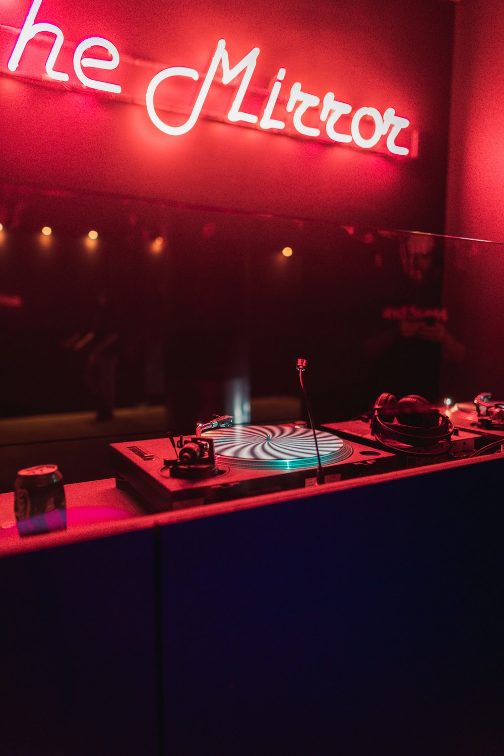 a dj booth with a neon sign in the background