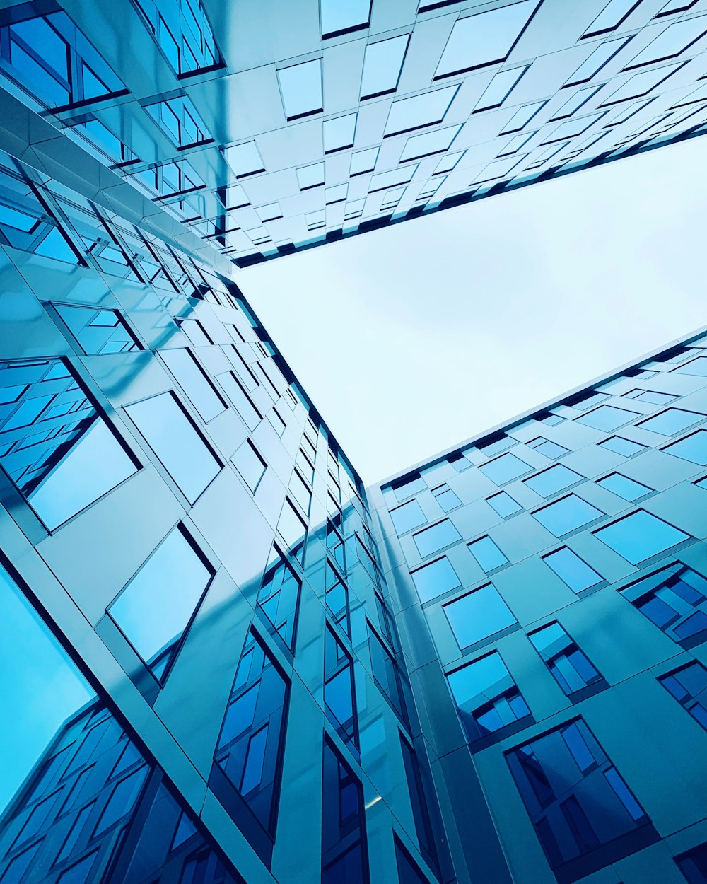 low angle photography of glass building under blue sky during daytime