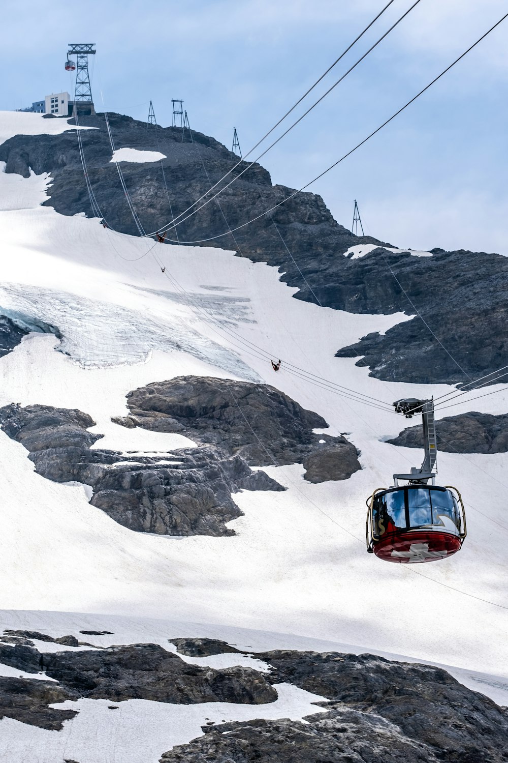 red car on snow covered mountain during daytime