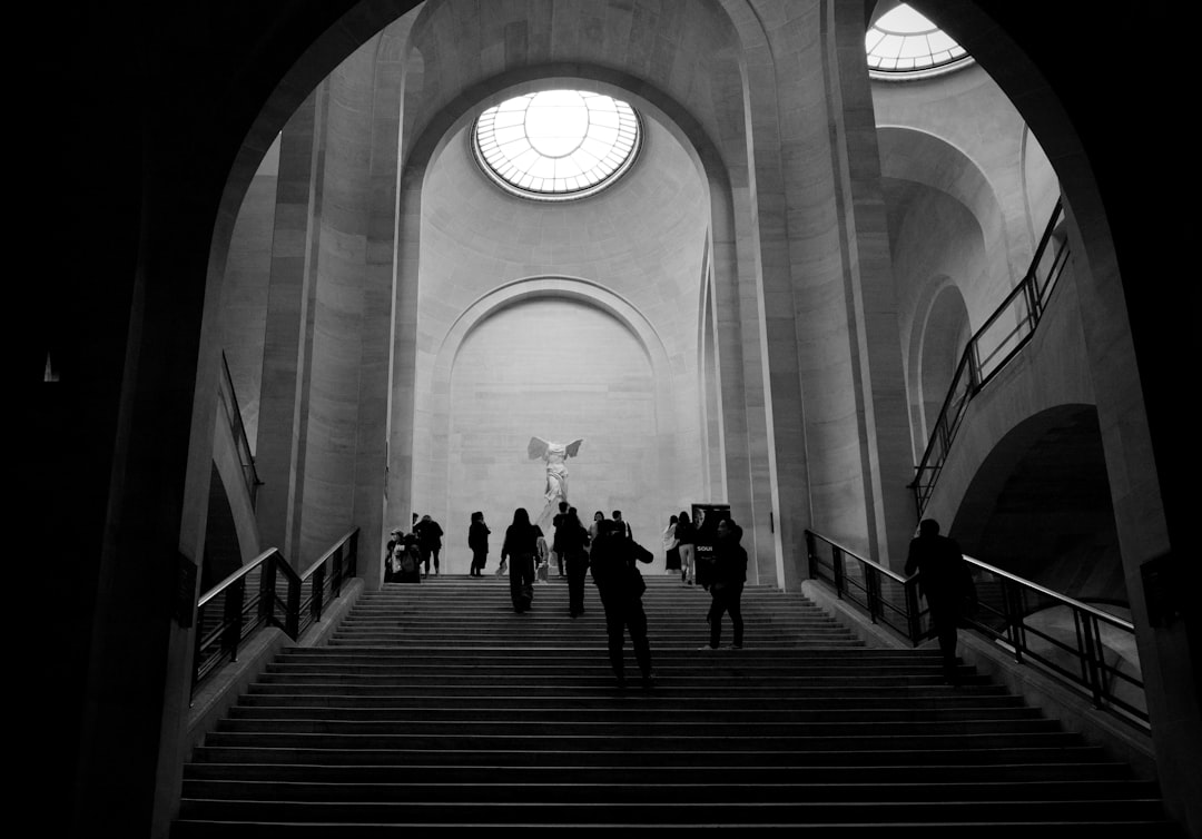 grayscale photo of people walking on stairs