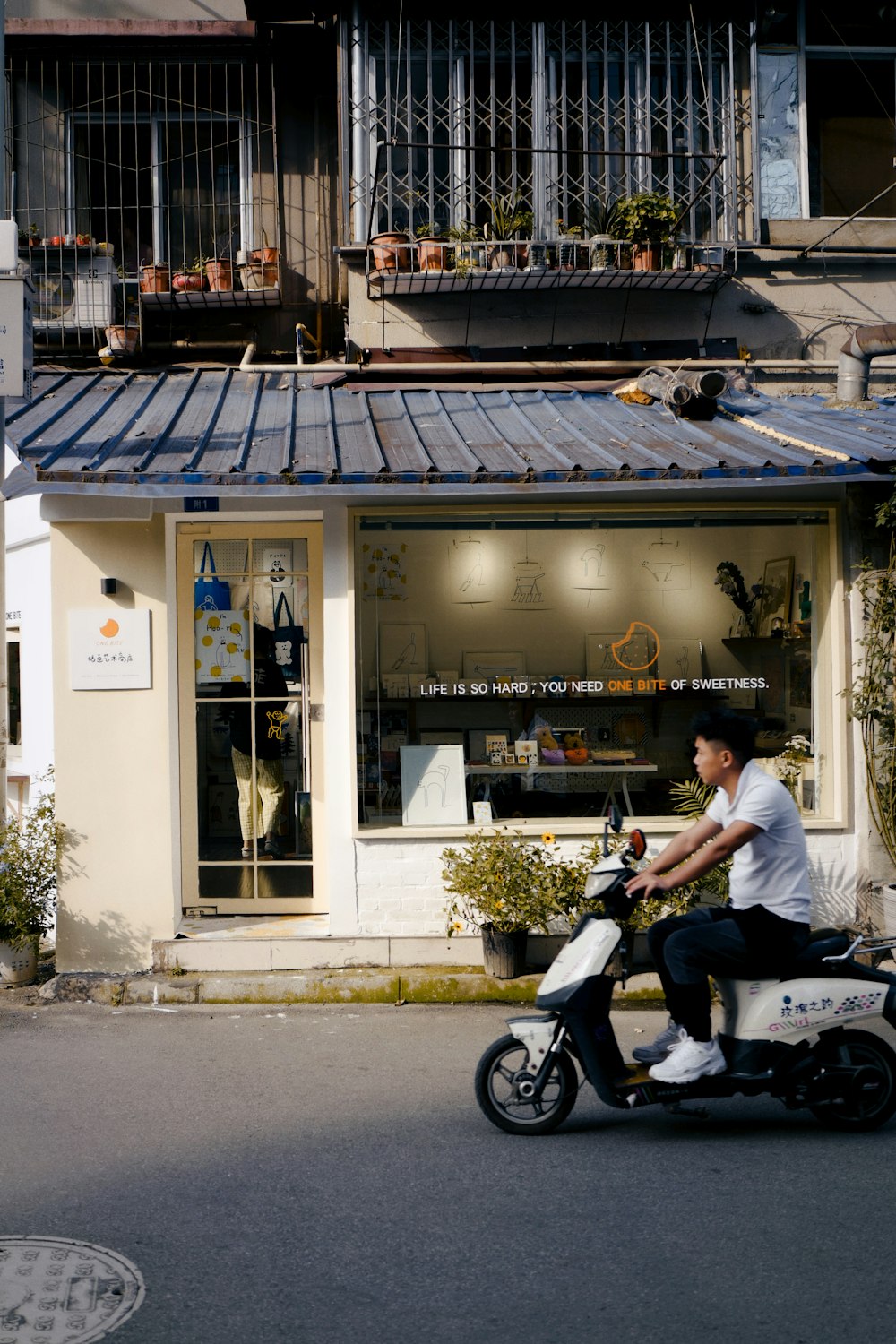 man in white t-shirt riding on black motorcycle during daytime