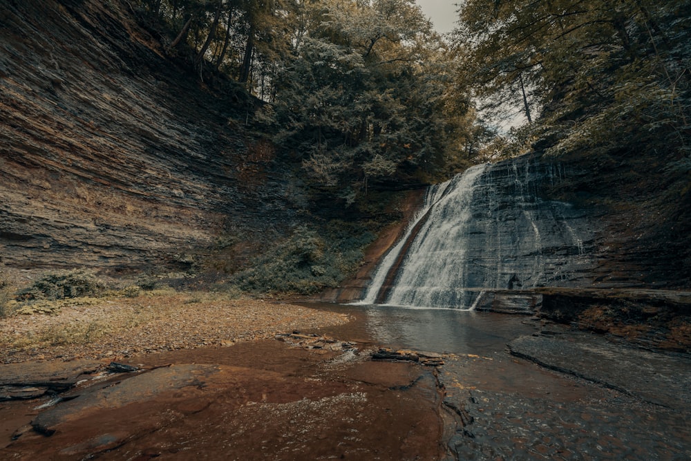 waterfalls in brown rocky mountain during daytime