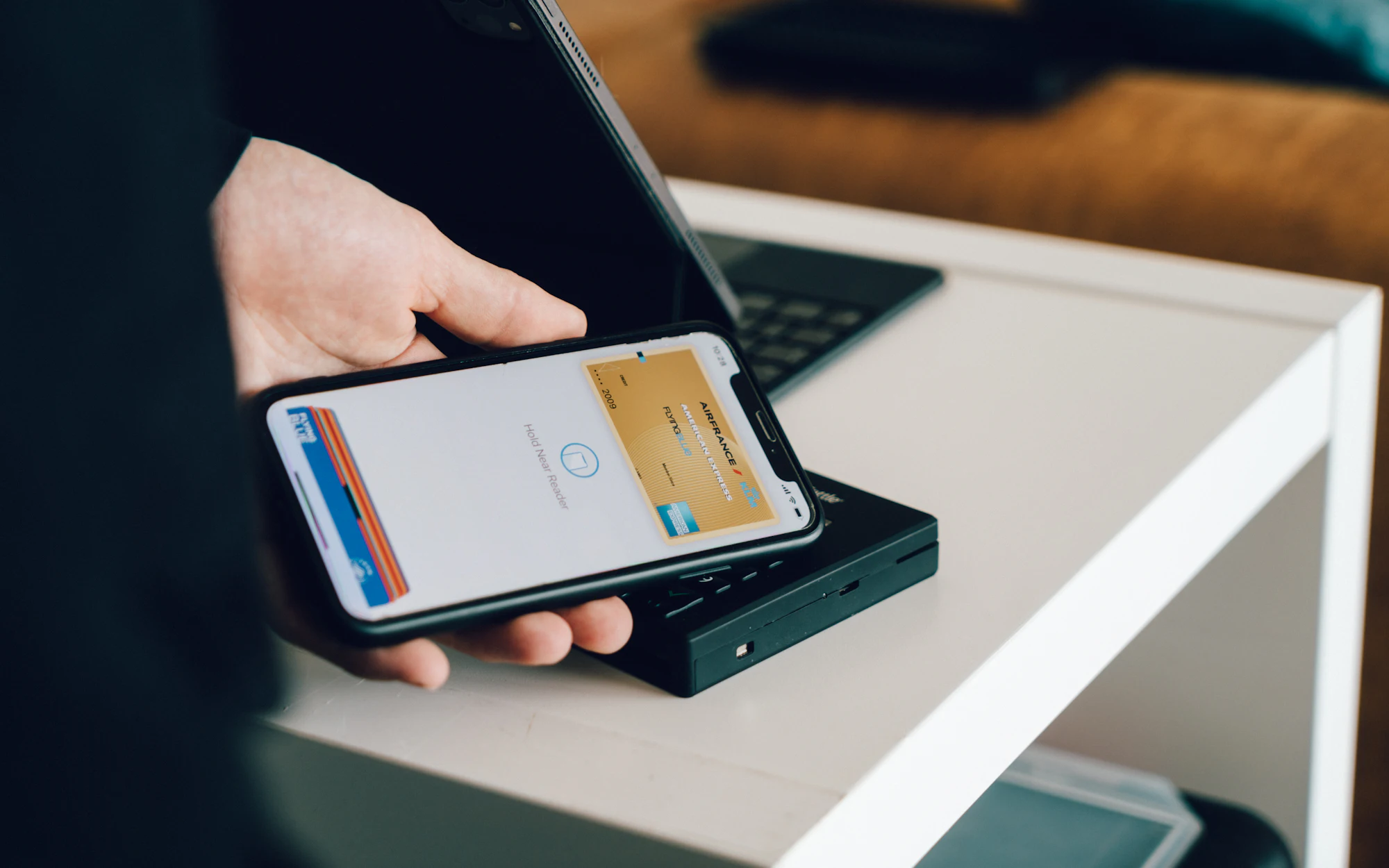 A person paying with a phone at a card reader