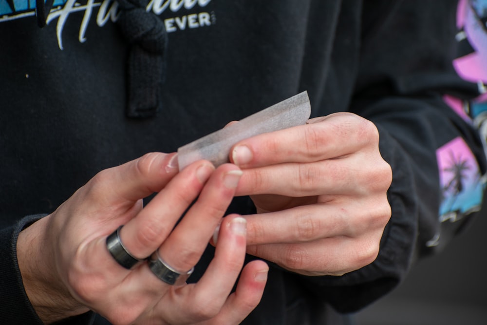 person in black long sleeve shirt wearing silver ring