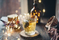 A cozy home setting with someone pouring tea from a Qarshi herbal bottle, surrounded by natural elements.