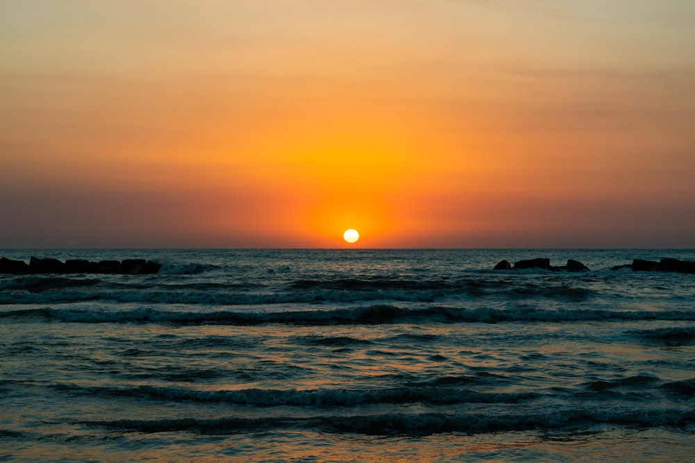 Meereswellen, die bei Sonnenuntergang an Land stürzen