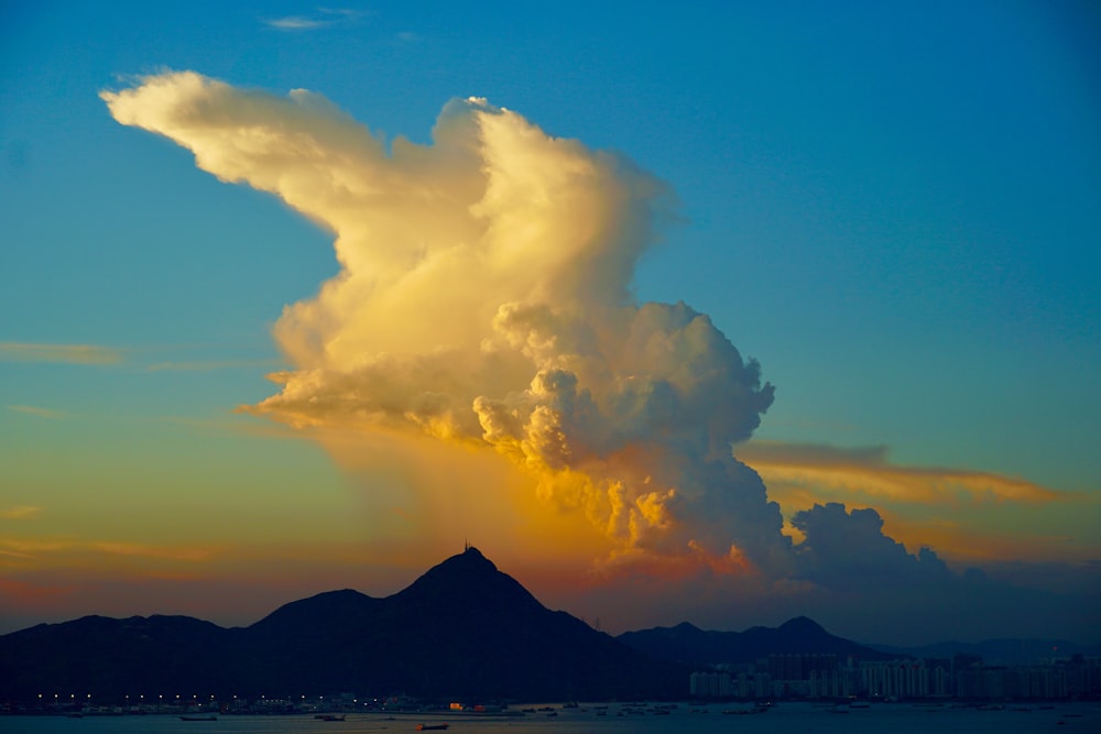 white clouds over mountain during daytime