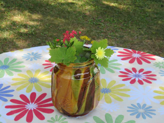 A vibrant hand-thrown stoneware vase glazed in cheerful yellow on a soft linen cloth.
