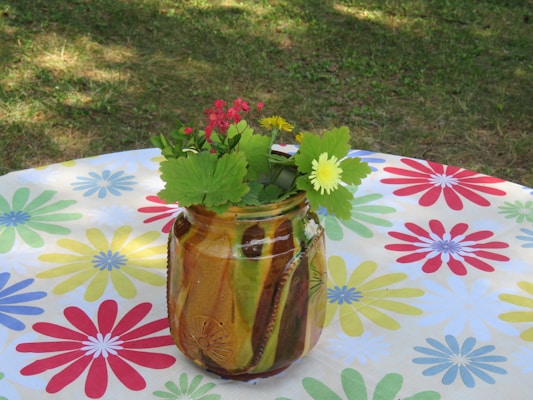 A vibrant 3D-printed vase with intricate floral patterns, showcased on a wooden table.