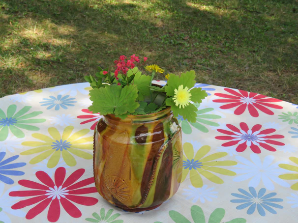 A vibrant hand-thrown stoneware vase glazed in cheerful yellow on a soft linen cloth.
