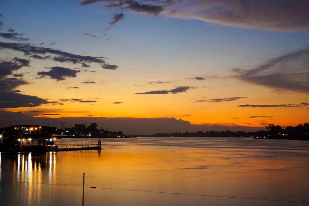 silhouette of people on dock during sunset