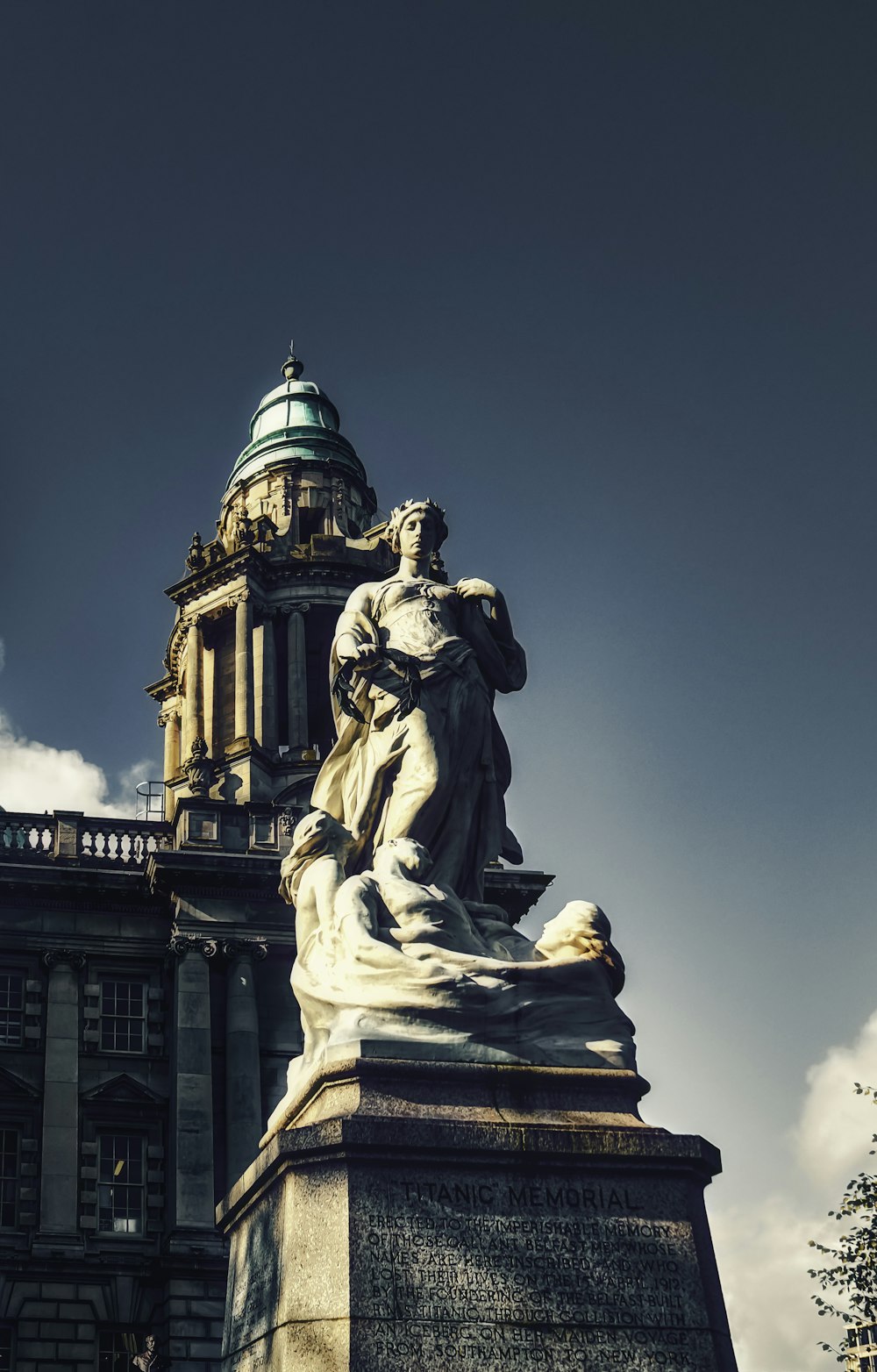 Estatua del hombre frente al edificio de hormigón marrón