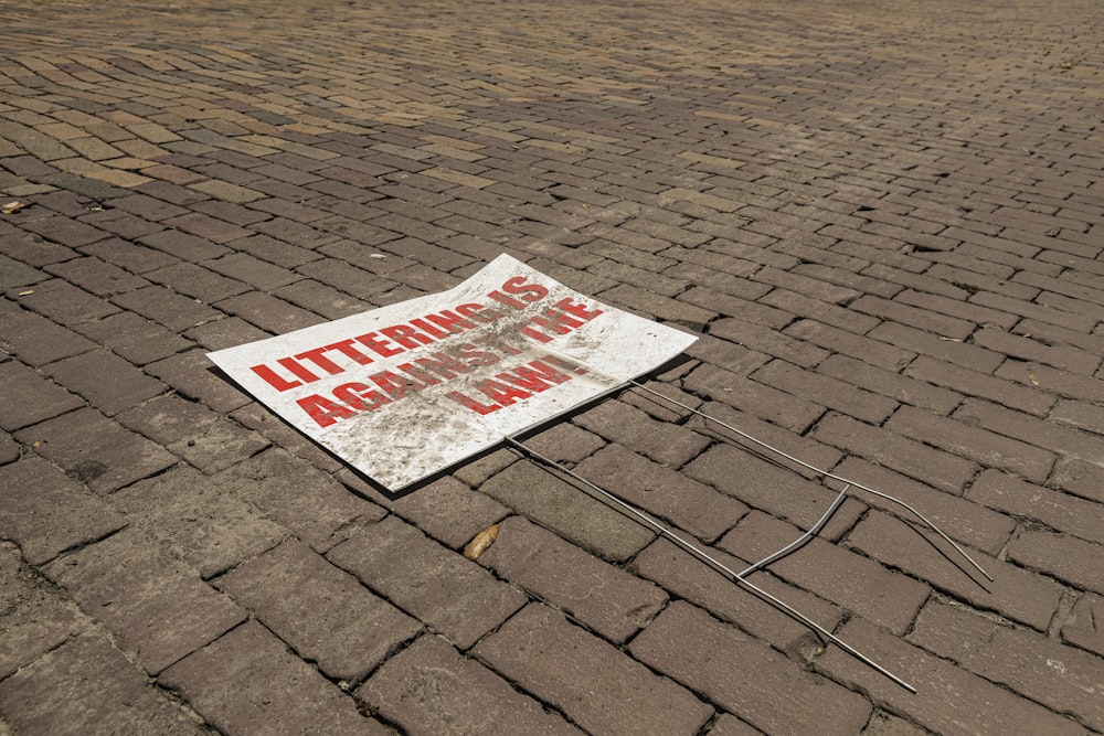 white and red no parking sign on brown brick floor