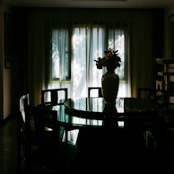 Elegant dining room illuminated by soft natural light through translucent blinds.