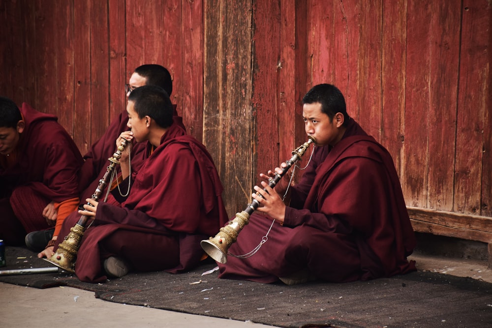 man in red robe playing flute
