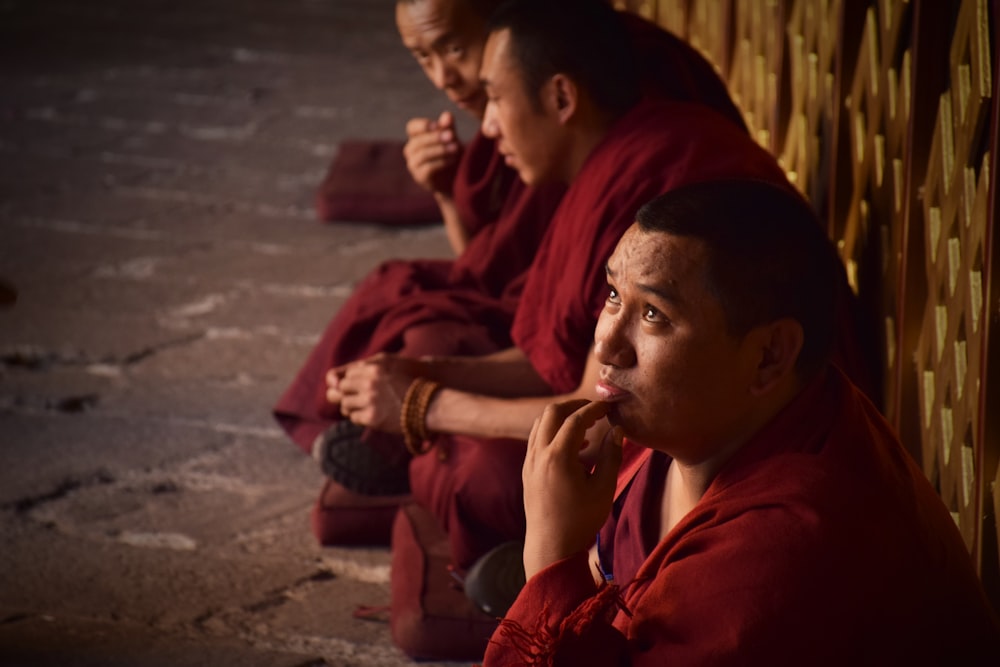 man in red robe sitting beside woman in red hijab