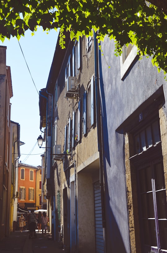 blue and yellow concrete buildings during daytime in L'Isle-sur-la-Sorgue France