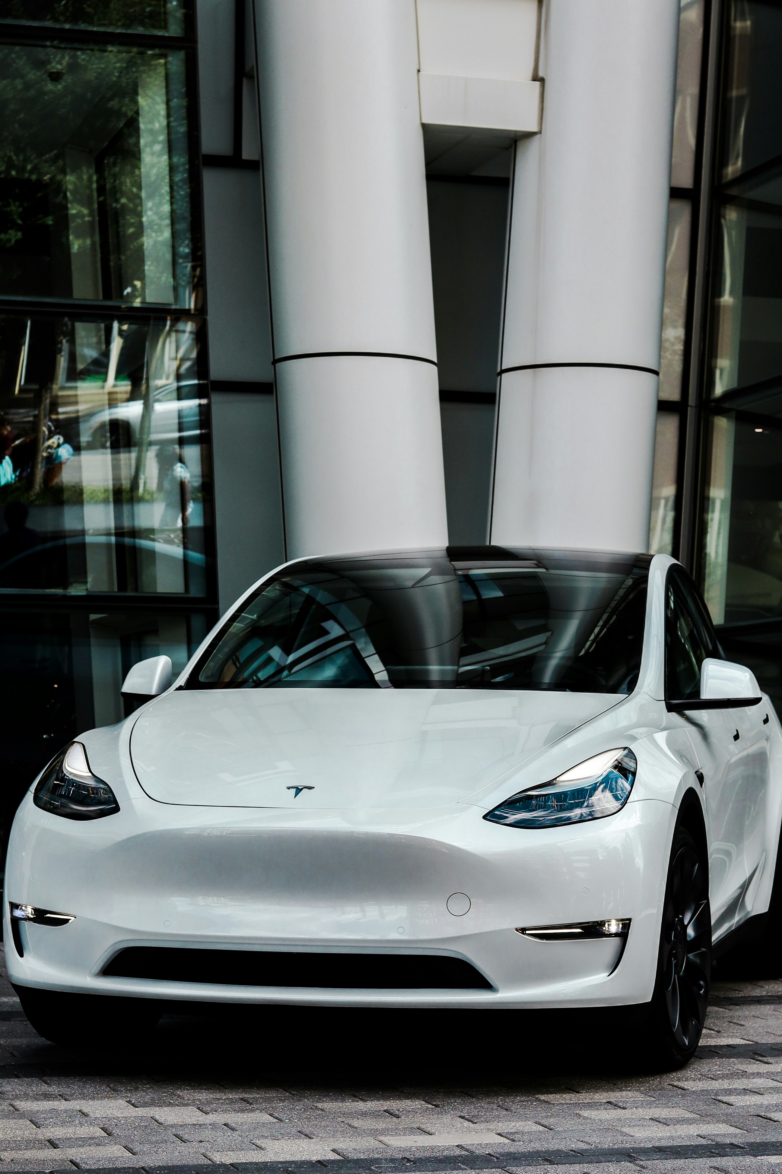 white porsche 911 parked in front of glass window