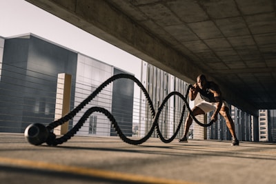 A fitness influencer demonstrating a high-intensity workout in an urban gym setting.