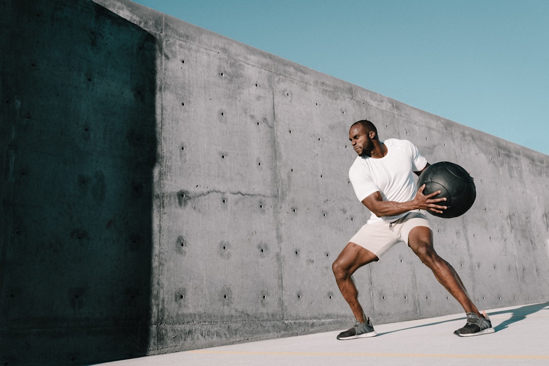 man in white t-shirt and white shorts running on gray concrete road during daytime