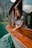 woman in blue and white stripe shirt sitting on brown wooden boat