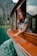 woman in blue and white stripe shirt sitting on brown wooden boat