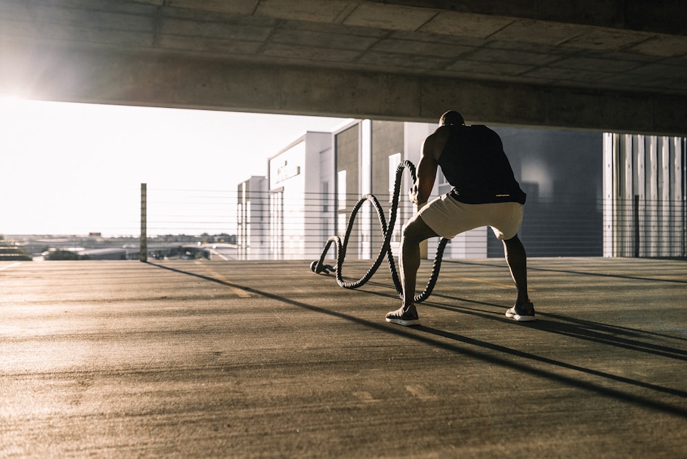 man in black t-shirt and white shorts walking on brown wooden floor