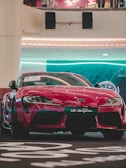 A sleek red sports car gleaming under showroom lights.