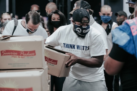 man in white crew neck t-shirt holding white box