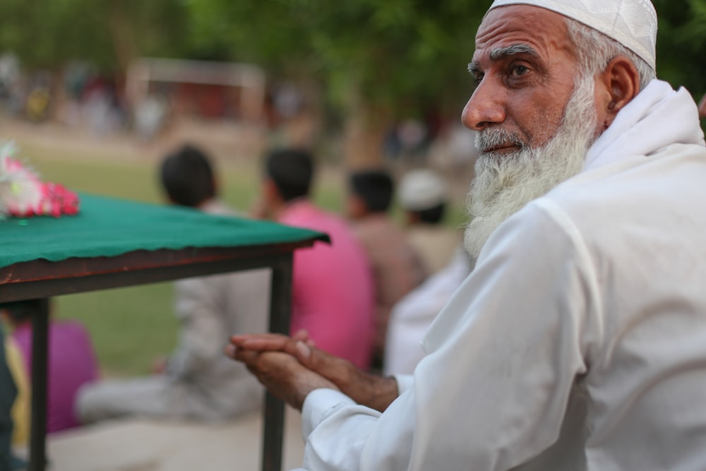 man in white thobe sitting on chair