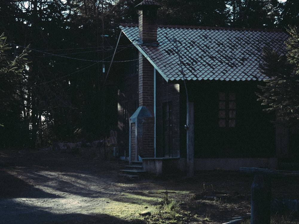 white and gray wooden house near green trees during daytime