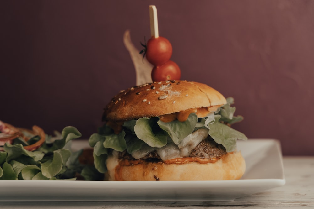 burger with lettuce and tomato on white ceramic plate